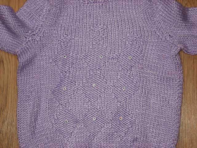 Margaret's purple sweater with buttons across the midsection